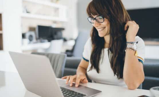 Femme heureuse travaillant sur un ordinateur