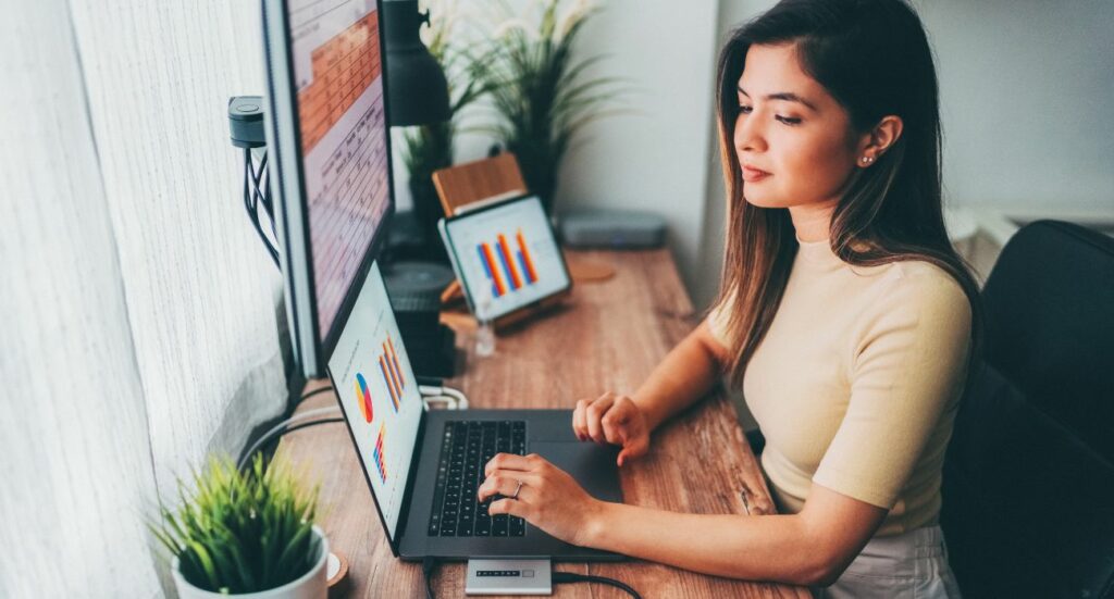 Femme travaillant devant un ordinateur et regardant ses statistiques